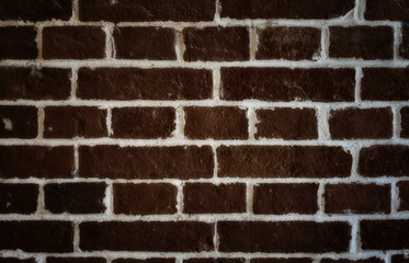 Rough dark brick wall with light joints.