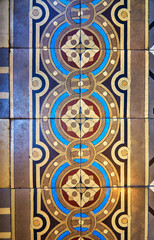 Colorful ceramic tiles with floral and geometric patterns for wall and floor decoration. Old concrete block surface background.