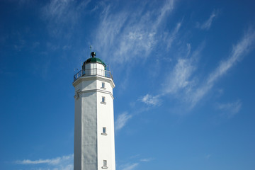 lighthouse on the beach with blue sky