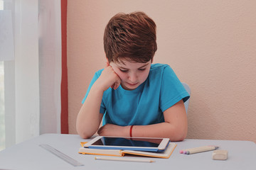 Naklejka na ściany i meble child studying at home using a tablet