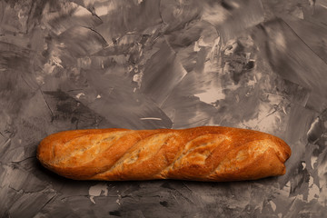 Composition with a bread on a textured plastered surface
