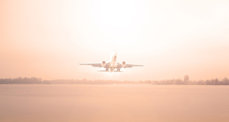 Fototapeta na wymiar Airplane over the lake and red sunset