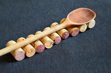 wooden spoon and corks for wine  on a black board