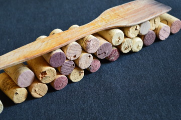 wooden spoon and corks for wine  on a black board