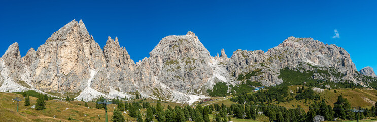 Fototapeta na wymiar Panoramic view of magical Dolomite peaks of Pizes da Cir, Passo Gardena at blue sky and sunny day, South Tyrol, Italy, wide angle