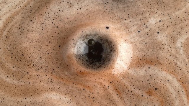 Coffee Drop Dripping to the Black Foamed Liquid Making Splash and Ripples
