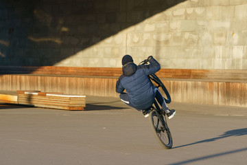 BMX in Moscow park. Brave young biker doing stunt. He doing trick on bike in spring day. Extreme...