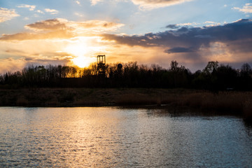 Fototapeta premium sunset at the lake with a beautiful sky and coal mining mines, czech karvina OKD