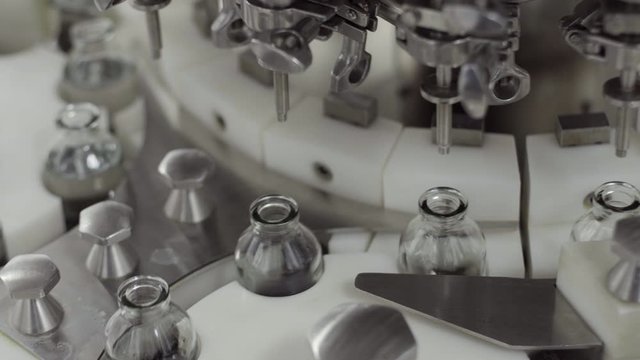 glass bottles on a medical solution conveyor at filling station close up medical industry