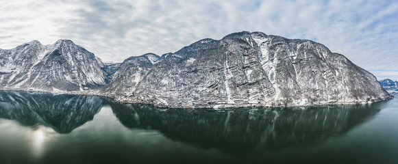 Aerial panoramic drone view of Hallstatt lake surrounded by snow