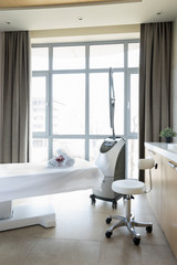 Close up view of cosmetology apparatus and empty massage table in salon