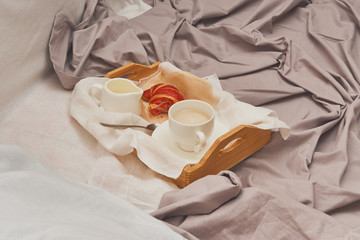 Fototapeta na wymiar Breakfast in bed, coffee with cream, croissants in jam