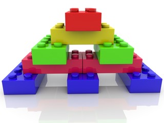 Fototapeta premium Colored toy brick pyramid with red brick at the top