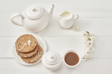 Obraz na płótnie Canvas Tea set, cookies and white lilac on kitchen table. Happy birthday greeting card. Hello spring and summer. Greeting card for Women's Day and Mother's Day. Spring season, copy space.Romantic breakfast