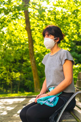 Social distance, a young girl sitting with a mask in the coronavirus pandemic