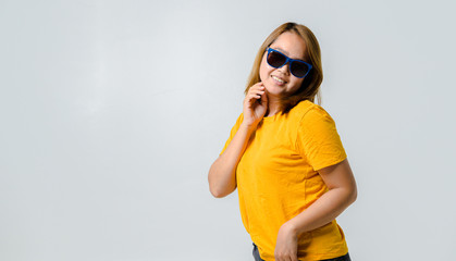 Fototapeta premium Beautiful young woman with yellow t-shirt and sunglasses feeling funny happy on yellow colour background,Summer concept banner background.panoramic banner concept background with space.