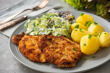 Chop pork cutlets , served with boiled potatoes and salad. - obrazy, fototapety, plakaty