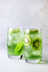 Glass of Refreshing Tropical Kiwi Lemonade With Ice on Light Gray Background Tasty Summer Beverage Healthy Detox Diet Drink Vertical