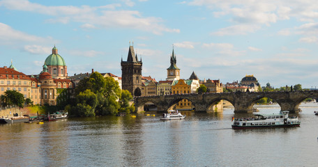 Charles bridge, Old Town Bridge Tower and a green dome church beside Moldava river seen from Mala Strana (Lesser Town) in Prague, Czech Republic
