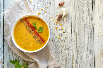 Pea soup in a white bowl. Pea cream soup in a plate on a light wooden background. Healthy vegan food. Free space for text. Top view.