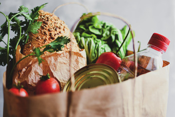 Food in a paper bag. Food donation or food delivery concept. Free space for text. Oil, bread,...