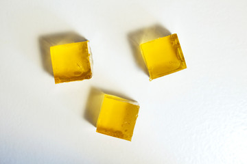 Yellow jelly cubes on a white background