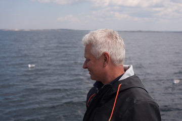 Fototapeta premium Portrait of a fisherman in a rain jacket on a boat