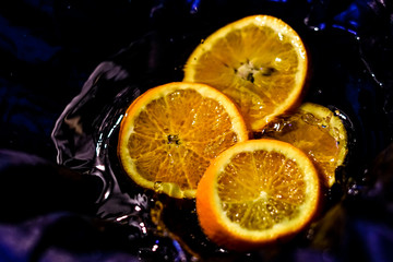 sliced ​​orange in water with splashes
