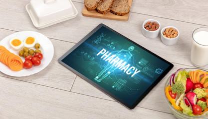 PHARMACY concept in tablet with fruits, top view