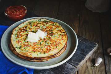Thin pancakes with herbs. Salty Pancakes with green onions. Wood background. Vintage background. Delicious food for a bite to eat. Free space for text. Blue linen napkin