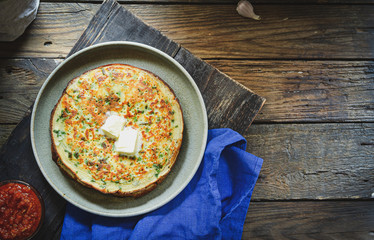 Thin pancakes with herbs. Salty Pancakes with green onions. Wood background. Vintage background. Delicious food for a bite to eat. Free space for text. Top view. Blue linen napkin.