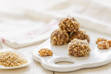 
chocolate cake on a plate. cocoa and nuts. white background and a towel. Rustic style in food photography