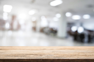 Empty wooden table and blurry background of white bokeh light department store for product display montage.