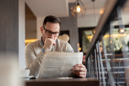 Pensive man reading newspaper