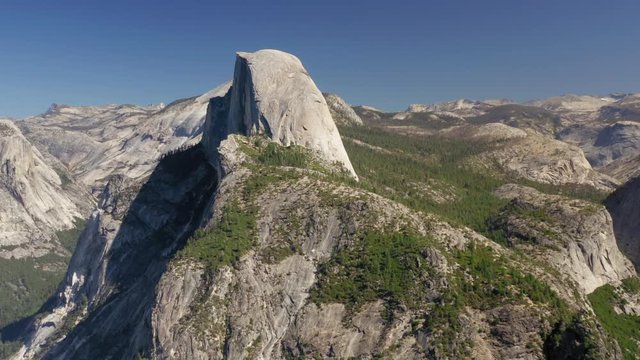 Close-up aerial footage of the popular landmark of North America, located in Yosemite National Park, in California, USA - The Half Dome rock. Unique granite formation of Sierra Nevada range. 4K