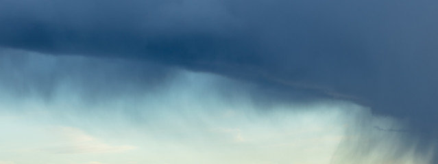 Naklejka premium Panoramic view of awesome black clouds before storm. Blue/Black clouds and rain coming.