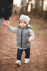 A young mother and her cute little son are walking in the Park