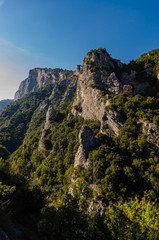 Beautiful view of the cliffs covered with green forest. Scenic views from the tourist walking trail of the Baths of Zeus