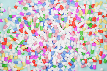 Fototapeta na wymiar top view of colorful pill capsules on light green background, 3D rendering 