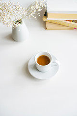 books, coffee mug glasses and pink rose on the table on a white background