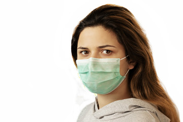 Studio portrait of young woman wearing a face mask, looking at camera, close up, isolated on white background