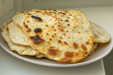 a plate of fried tortillas stands on a windowsill.