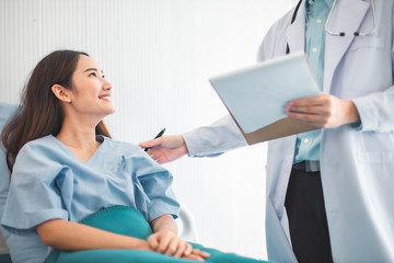  Medicine and health care concept.  Asian doctor is taking care patient woman in hospital.doctor or nurse wear protection mask checking and takecare infection people from covid-19 .