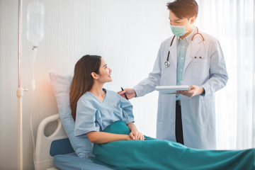Obraz premium Medicine and health care concept. Asian doctor is taking care patient woman in hospital.doctor or nurse wear protection mask checking and takecare infection people from covid-19 .