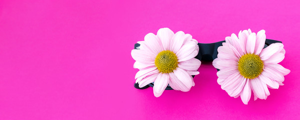 Sunglasses with pink chrysanthemum flowers instead of glasses on a pink background.Summer is coming concept.Copy space for text