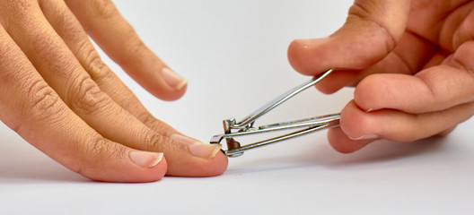 hands cutting nails on white background