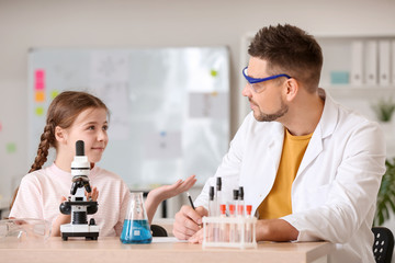Teacher and pupil at chemistry lesson in classroom