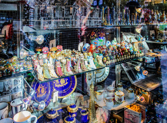 Parisian window with Souvenirs. Statuettes, symbols of the city and attractions, dishes, mugs, plates, the Eiffel tower. Shopping on site. France.