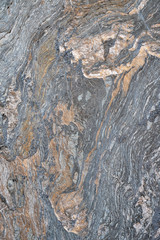 strukturierter, bröckeliger, grauer Fels mit Muster und Mineralienlinien