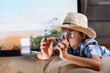 Boy in straw hat lying down and imitating scouting